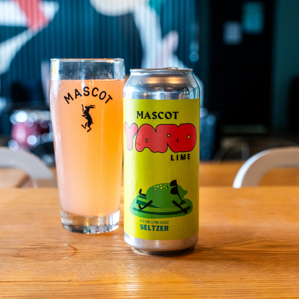 Can of Mascot's Yard Lime Seltzer next to a filled up, Mascot branded glass.
